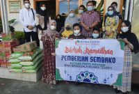 Pimpinan bank Kalteng Cabang Muara Teweh, Akhmad Guniardi saat menyalurkan paket sembako ke salah panti asuhan.