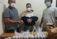 Pelaku (tengah) saat diamankan petugas bersama barang bukti