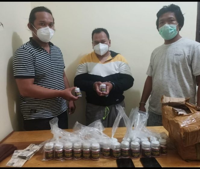 Pelaku (tengah) saat diamankan petugas bersama barang bukti