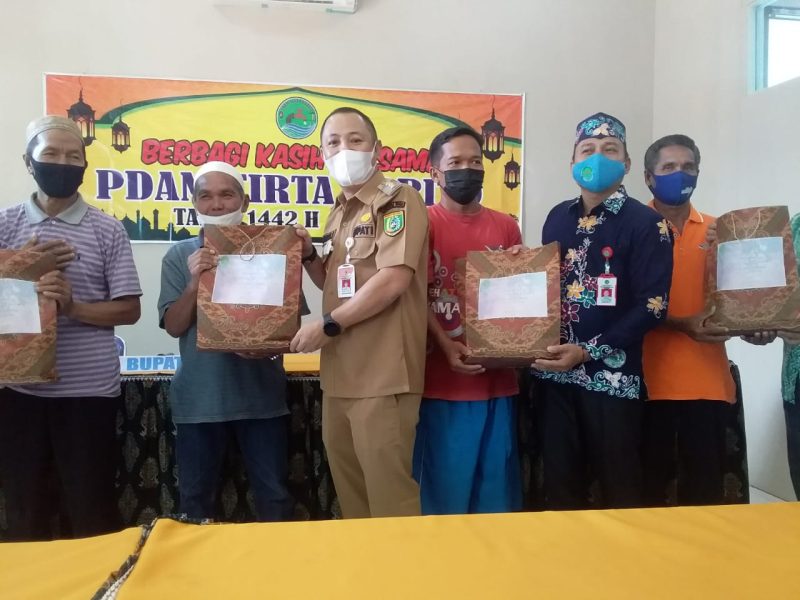 Foto ; Bupati Barsel H. Eddy Raya Samsuri (kiri) saat memberikan paket sembako secara simbolis, dan Direktur PDAM Tirta Barito Rona Cipta (kanan baju batik)