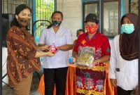 Ketua TP-PKK Mura, Lynda Kristiane Perdie menyerahkan bingkisan