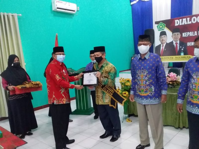 Foto : Dr. H. Abdul Rasyid, M. Ag,Kakanwil Kalteng, saat memberikan piagan duta moderasi kepada Drs. H. Tuaini Ismail, M. Ag. Kepala Kemenag Barsel.