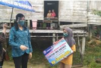Ketua TP PKK Mura Lynda Kristiane Perdie saat menyerahkan bantuan kepada ibu Hayati warga desa Muara Jaan