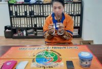 Bella saat menunjukkan barang bukti serbuk putih diduga narkotia jenis sabu-sabu.