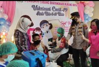 Kapolres Mura AKBP I Gede Putu Widyana bersama istri saat melihat pelaksanaan vaksinasi anak. Foto : Suroso/1tulah.com
