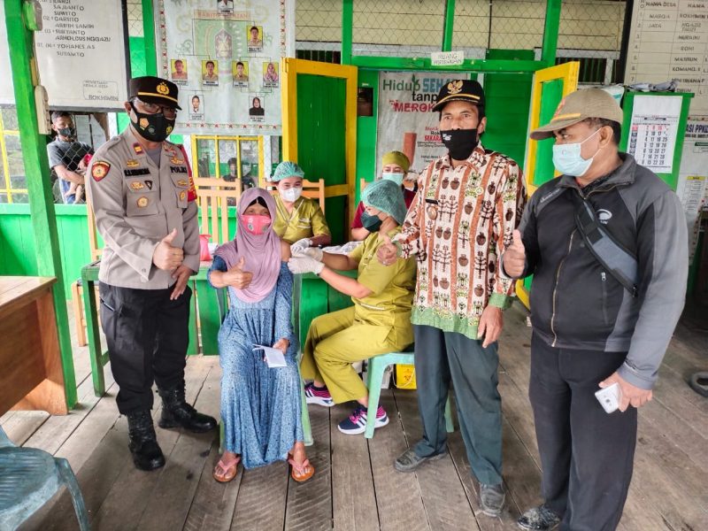 Kapolsek Gunung Bintang Awai (kiri) Mendampingi Anak yang Divaksin. Foto: Alifansyah/1tulah.com.