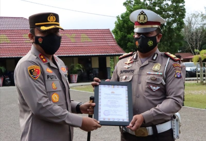 Kapolres Mura AKBP I Gede Putu Widyana menyerahkan penghargaan kepada Kasatlantas
 AKP Suprianto. Foto : Suroso/1tulah.com.