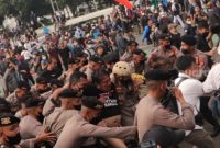 Dosen sekaligus aktivis Ade Armando diamankan polisi dari amukan massa. (Suara.com)