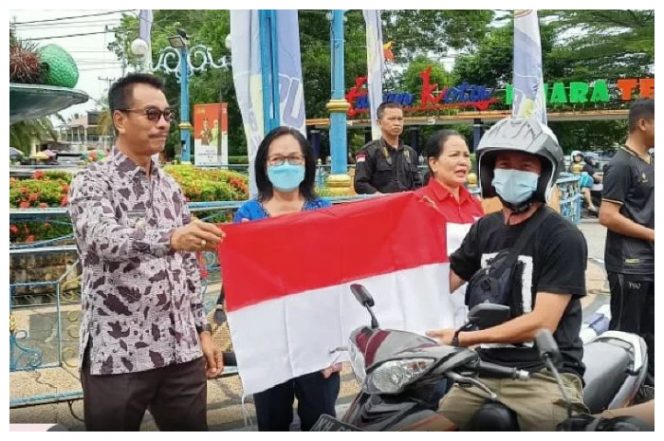Wakil Bupati Sugianto Panala Putra bersama istri saat membagikan bendera merah putih di bundaran HI.Foto.Delia/1tulah.com