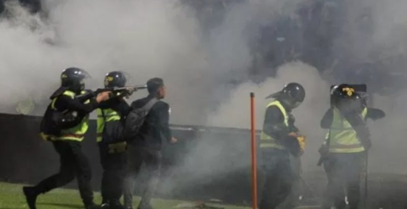 Aparat keamanan menembakkan gas air mata untuk menghalau suporter yang masuk lapangan usai pertandingan sepak bola BRI Liga 1 antara Arema melawan Persebaya di Stadion Kanjuruhan, Malang, Sabtu (1/10/2022) (suara.com)