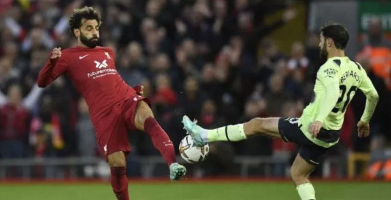 Penyerang Liverpool, Mohamed Salah (kiri) berebut bola dengan gelandang serang Manchester City, Bernardo Silva pada laga Liga Inggris di Anfield, Senin (17/10/2022) dini hari WIB. (AFP/suara com)