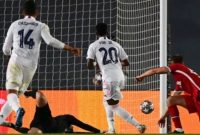 Penyerang Real Madrid Vinicius Junior (tengah) merobek gawang Liverpool lewat sepakan pelan yang tak mampu diamankan kiper Alisson Becker dalam laga leg pertama babak perempat final Liga Champions 2020/2021 di Estadio Alfredo Di Stefano, Rabu (7/4/2021) dini hari WIB. [GABRIEL BOUYS / AFP].