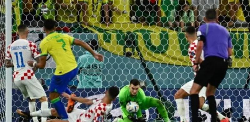 Kiper Timnas Kroasia, Dominik Livakovic (tengah) melakukan penyelamatan bola pada laga perempat final Piala Dunia 2022 kontra Brasil di Stadion Education City, Qatar, Jumat (9/12/2022) malam WIB. [Jewel SAMAD / AFP]