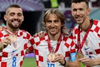 Kiri-Kanan) Gelandang Kroasia Mateo Kovacic, Luka Modric dan Ivan Perisic memamerkan medali mereka setelah memenangkan pertandingan play-off perebutan tempat ketiga Piala Dunia 2022 antara Kroasia dan Maroko di Stadion Internasional Khalifa di Doha, Qatar, Sabtu (17/12/2022). [JACK GUEZ/AFP]