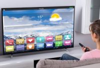 Ilustrasi seorang perempuan mencoba Smart TV. Sumber foto : suara.com