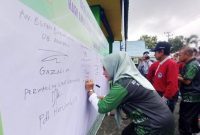 Anggota DPRD Barito Utara, Hj Nety Herawati membubuhkan tandatangan di baliho pencanangan Kerukunan Umat pada peringatan Hari Amal Bhakti (HAB) ke 77 tahun 2023, di Muara Teweh, Minggu (15/01/2023). Foto.Delia Anisya Fitri/1tulah.com 