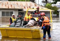 Sejumlah petugas tanggap darurat (SES) mengevakuasi warga dan barang-barang bawaan di sebuah kendaraan air di Kota Forbes, negara bagian New South Wales, Australia. (voaindonesia.com)