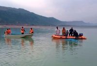 Petugas penyelamat mencari korban tewas di lokasi perahu yang terbalik di danau Tanda, di Kohat, Pakistan barat laut, Minggu, 29 Januari 2023. Sumber foto : voaindonesia.com
