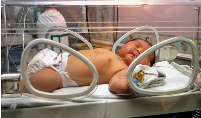 Seorang bayi tidur di dalam inkubator di rumah sakit Fatmawati, Jakarta, 05 Desember 2007. Sang ibu, Ernawati, melahirkan bayi terberat di Indonesia, bayi laki-laki dengan berat 6,9 kilogram. Ibu berusia 37 tahun itu menderita diabetes gestasional, yang membuat bayi berisiko menjadi lebih berat dari biasanya. (Foto oleh Adek BERRY/AFP)
