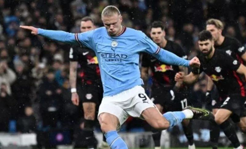 Striker Manchester City Erling Haaland menembak dari titik penalti untuk mencetak gol pembuka timnya selama leg kedua babak 16 besar Liga Champions antara Manchester City vs RB Leipzig di Stadion Etihad di Manchester, Inggris barat laut, pada 14 Maret , 2023. Paul ELLIS / AFP.
