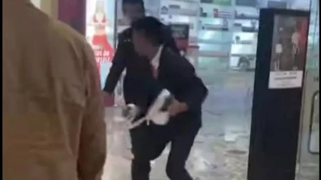 Petugas keamanan berupaya memadamkan api agar tidak meluas ke bagian toko lainnya. Sumber foto : suara.com