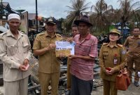 Bupati Murung Raya Perdie M Yoseph menyerahkan bantuan untuk korban kebakaran di Desa Mangkahui, Senin (10/04/2023). (foto : Suroso/1tulahm.com)