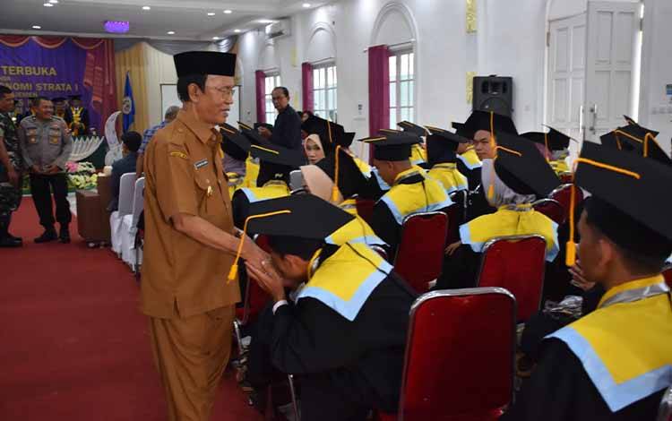 
Wabup Kapuas HM Nafiah Ibnor menyalami wisudawan Program S1 STIE Kuala Kapuas. Foto:Istimewa
