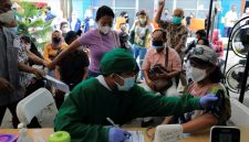 Seorang tenaga medis melakukan pemeriksaan kesehatan terhadap seorang perempuan yang akan menerima dosis vaksin booster COVID-19 di Jakarta, 12 Januari 2022. (Foto : REUTERS/Willy Kurniawan)