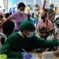 Seorang tenaga medis melakukan pemeriksaan kesehatan terhadap seorang perempuan yang akan menerima dosis vaksin booster COVID-19 di Jakarta, 12 Januari 2022. (Foto : REUTERS/Willy Kurniawan)