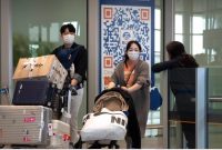 Sejumlah pelancong mengenakan masker saat tiba di area kedatangan Bandara Internasional Beijing pada 26 April 2023. (Foto: AP/Mark Schiefelbein)
