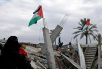Anggota keluarga Palestina duduk di lokasi rumah mereka yang hancur, pada sebuah hari musim dingin di selatan Jalur Gaza. [REUTERS/Mohammed Salem/wsj/cfo (REUTERS/MOHAMMED SALEM]