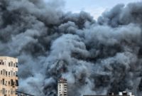 Kepulan asap membubung di atas gedung-gedung yang terkena serangan udara Israel di Kota Gaza, Palestina, Sabtu (7/10/2023). [MAHMUD HAMS / AFP]