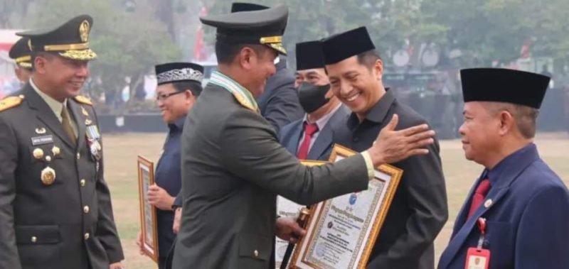 Pj. Bupati Barito Utara, Drs. Muhlis saat menerima penghargaan penghargaan Operasi Bakti TNI tahun 2023 yang diserahkan oleh  Pangdam XII/TPR, Mayor Jendral TNI Iwan Setiawan, S.E., M.M di lapangan Makorem 102/Panju Panjung, Palangka Raya, Kamis (5/10/2023). Foto:Delia/1tulah.com