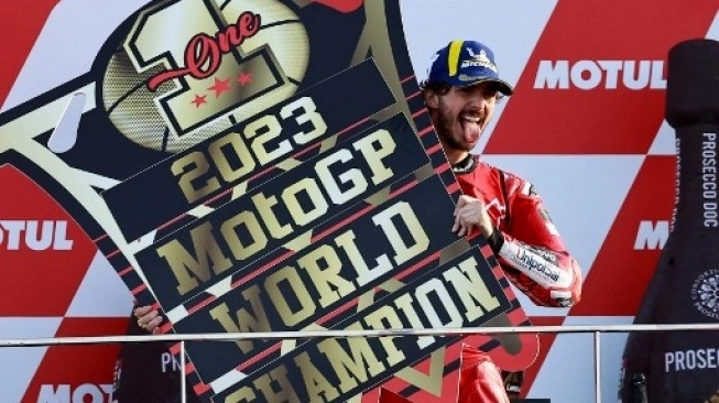Pembalap Ducati Italia Francesco Bagnaia merayakan di podium setelah memenangkan Grand Prix MotoGP Valencia. Sumber foto : suara.com
