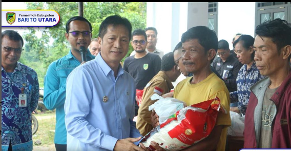 Pj Bupati Barito Utara, Drs Muhlis didampingi Plt Sekda, Jufriansyah saat menyerahkan paket sembako ke warga dalam acara operasi pasar murah, Kamis (16/11/2023).foto.humas kominfo/1tulah.com