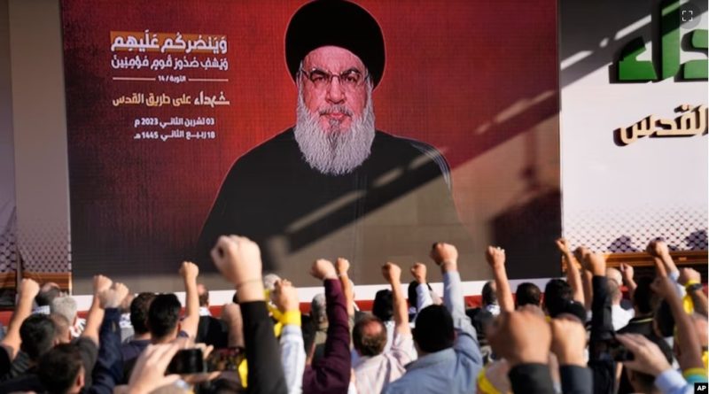 Pendukung kelompok Hizbullah yang didukung Iran mengacungkan tinju dan bersorak ketika pemimpin Hizbullah Sayyed Hassan Nasrallah muncul melalui tautan video selama rapat umum di Beirut, Lebanon hari Jumat, 3 November 2023.