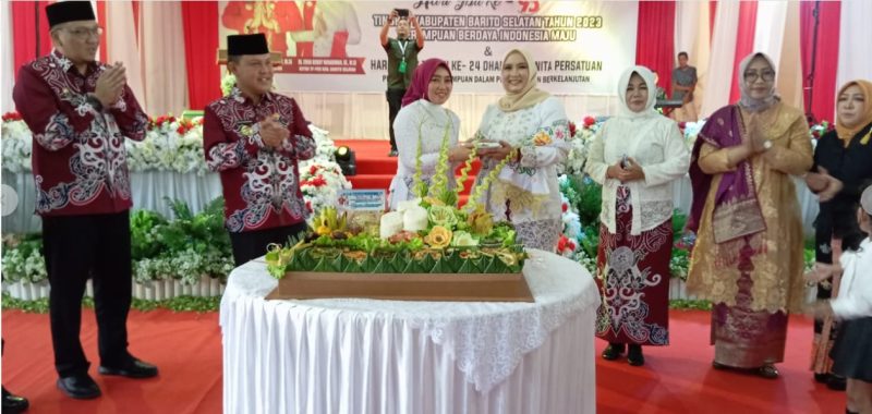 Ketua TP-PKK Kabupaten Barsel, Hj. Erna Deddy Winarwan didampingi Pj. Bupati H. Deddy Winarwan (tengah kerudung merah) saat menyerahkan potongan tumpeng kepada istri Sekda Barsel (tengah kanan) beserta Sekda Eddy Purwanto (kiri) pada puncak Peringatan Hari Ibu ke-95, di Buntok, Kamis (14/12/2023). Foto. Alifansyah/1tulah.com