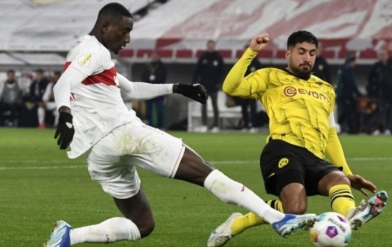 Penyerang Stuttgart #09 Serhou Guirassy (kiri) dan gelandang Dortmund #23 Emre Can berebut bola pada pertandingan babak 16 besar Piala Jerman (DFB Pokal) antara VfB Stuttgart dan Borussia Dortmund di Stuttgart, barat daya Jerman pada 6 Desember. 2023. Thomas KIENZLE / AFP.