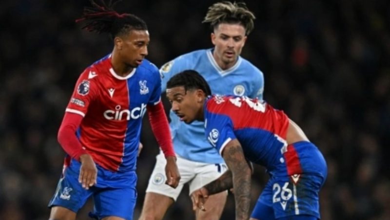 Gelandang Crystal Palace #07 Michael Olise (Kiri) bersaing dengan gelandang Manchester City #10 Jack Grealish selama pertandingan pekan ke-17 Liga Inggris 2023-2024 antara Manchester City vs Crystal Palace di Stadion Etihad di Manchester, barat laut Inggris, pada 16 Desember 2023. Paul ELLIS / AFP.