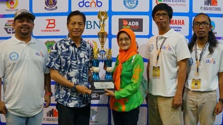 Pj. Bupati Barito Utara, Drs. Muhlis  menyerahkan trophy kepada pemenang Perlombaan Drum Corps North Barito Festival 2023 di Arena Terbuka Tiara Batara, Muara Teweh, Minggu (17/12/2023).Foto:Delia/1tulah.com