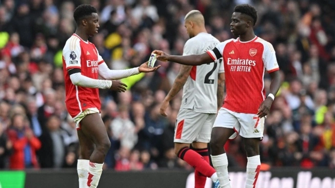 Gelandang Arsenal, Bukayo Saka (kanan) memberikan ban kapten kepada Eddie Nketiah (kiri) selama pertandingan Liga Inggris antara Arsenal dan Sheffield United di Stadion Emirates di London pada 28 Oktober 2023.  (sumber: suara.com)