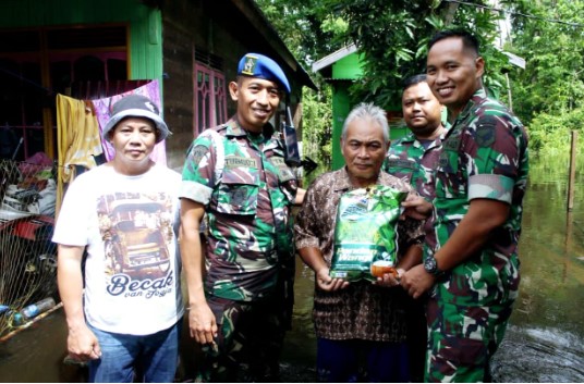 Dandim 1012/Buntok, Letkol Inf Hendro Wicaksono (kanan) bersama anggota didampingi Kades, Gapilon (kiri kaos putih) saat memberikan bantuan sembako kepada salah satu warga Desa Danau Ganting yang terdampak banjir. Minggu, (21/1/2024). Foto. Alifansyah/1tulah.com