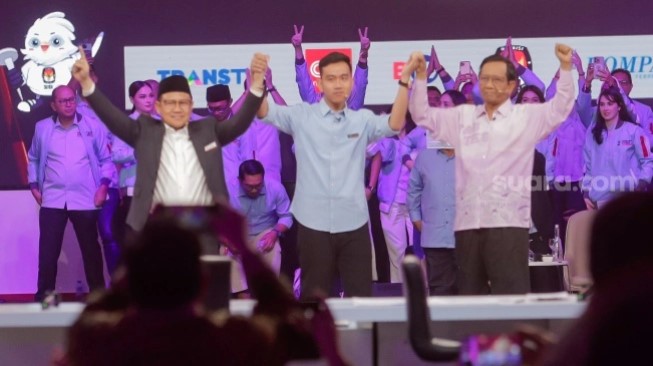 Cawapres nomor urut satu Muhaimin Iskandar (kiri), Cawapres nomor urut dua Gibran Rakabuming Raka (tengah) dan Cawapres nomor urut tiga Mahfud MD (kanan) saling berpegangan tangan usai debat perdana Cawapres 2024 di JCC Senayan Jakarta, Jumat (22/12/2023). [Suara.com/Alfian Winanto]