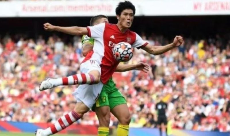 Pemain Arsenal Takehiro Tomiyasu berebut bola dengan pemain Norwich City dalam pertandingan Liga Premier, 11 September 2021. [AFP]