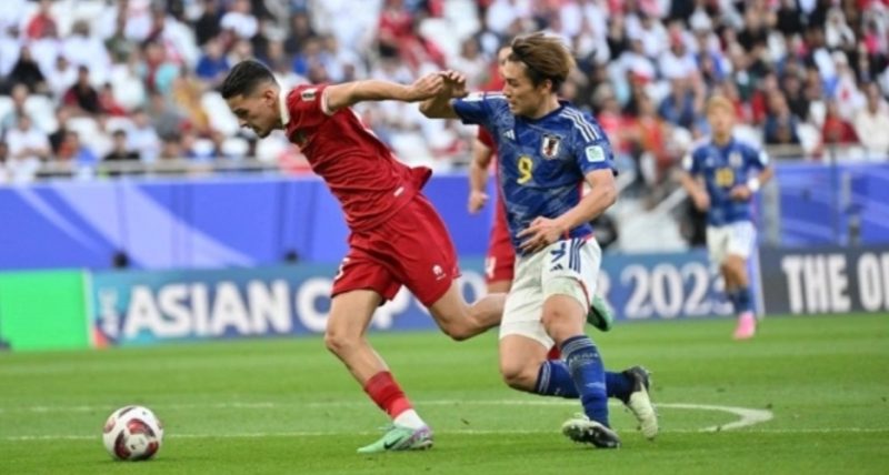 Penyerang timnas Jepang Ayase Ueda berebut bola melawan bek timnas Indonesia Justin Hubner pada pertandingan ketiga Grup D Piala Asia 2023 antara Jepang vs Timnas Indonesia di Stadion al-Thumama di Doha pada 24 Januari 2024. HECTOR RETAMAL / AFP