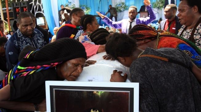 Warga memeluk peti jenazah mantan Gubernur Papua Lukas Enembe sebelum pemakaman di Koya Tenga, Kota Jayapura, Papua, Kamis (28/12/2023) (sumber: suara.com)