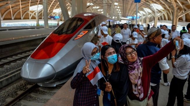 Warga berfoto dengan kereta cepat (sumber: suara.com)