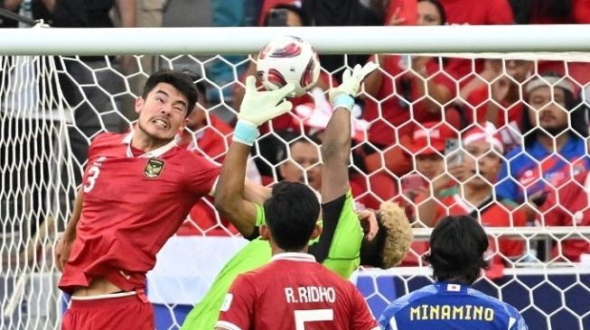 Penjaga gawang timnas Jepang, Zion Suzuki melompat untuk menyelamatkan bola hasil lemparan ke dalam Pratama Arhan. Gawang Jepang akhirnya bobol usai bola sundulan Elkan Baggott disambar Sandy Walsh (tak ada dalam foto) selama pertandingan terakhir Grup D Piala Asia 2023 antara Jepang vs timnas Indonesia di Stadion al Thumama di Doha pada 24 Januari 2024 (sumber: saura.com)