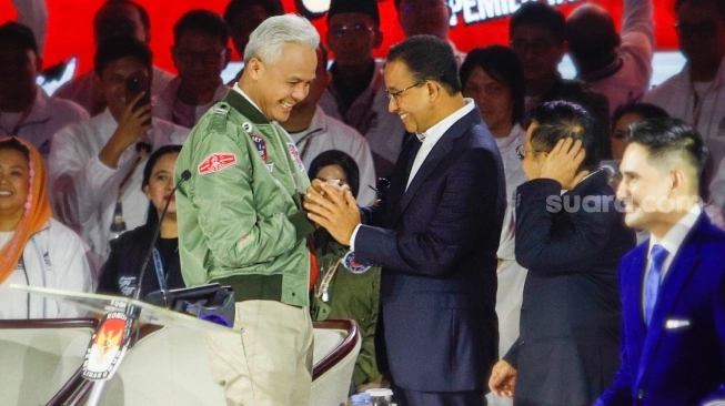 Capres nomor urut tiga, Ganjar Pranowo (kiri) bersalaman dengan Capres nomor urut satu, Anies Baswedan (kanan) saat Debat Capres Ketiga di Istora Senayan, Jakarta, Minggu (7/1/2024). (sumber: suara.com)