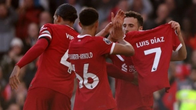 Striker Liverpool #20 Diogo Jota (kanan) mengangkat kaus bertuliskan nama gelandang Liverpool Luis Diaz saat ia merayakan golnya bersama rekan satu timnya setelah mencetak gol pembuka pertandingan sepak bola Liga Premier Inggris antara Liverpool dan Nottingham Forest di Anfield di Liverpool, Inggris barat laut pada 29 Oktober 2023 (sumber; suara.com)